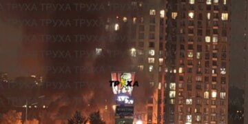 У Києві російський дрон влучив у 25-поверхівку, палають авто у дворі